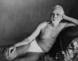 Photo of Ramana Maharshi reclining on couch close up gentle look in black and white
